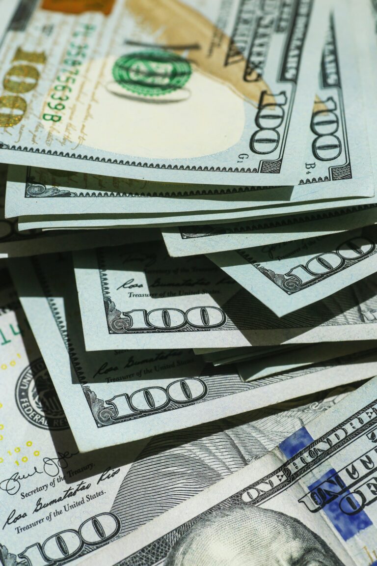 Tumpukan uang kertas dolar menggambarkan konsep dasar apa itu uang dan bagaimana cara kerjanya dalam sistem ekonomi