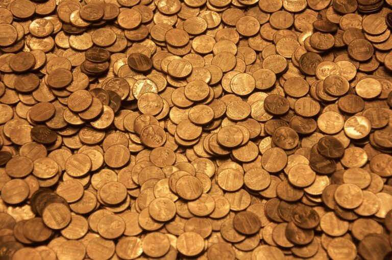 Koin coklat di atas permukaan kayu - mengubah uang menjadi aset emas
