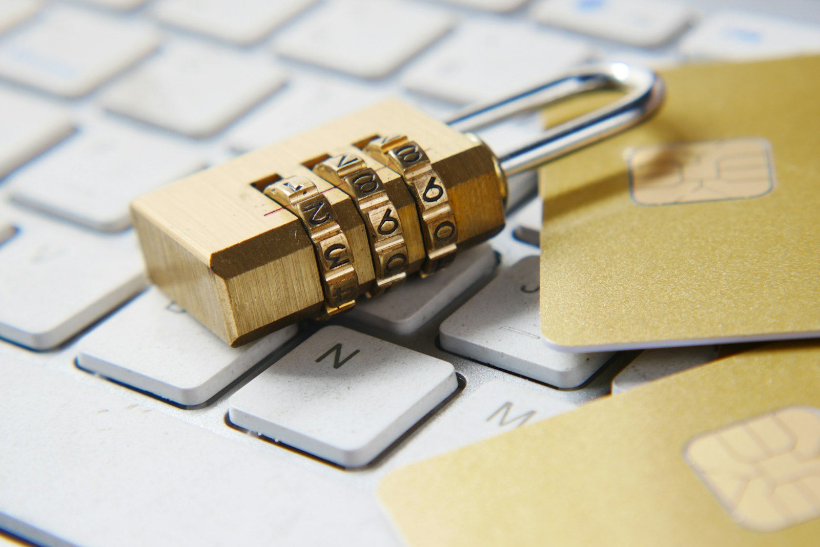Gembok emas di atas keyboard laptop melambangkan waspada penipuan investasi emas online